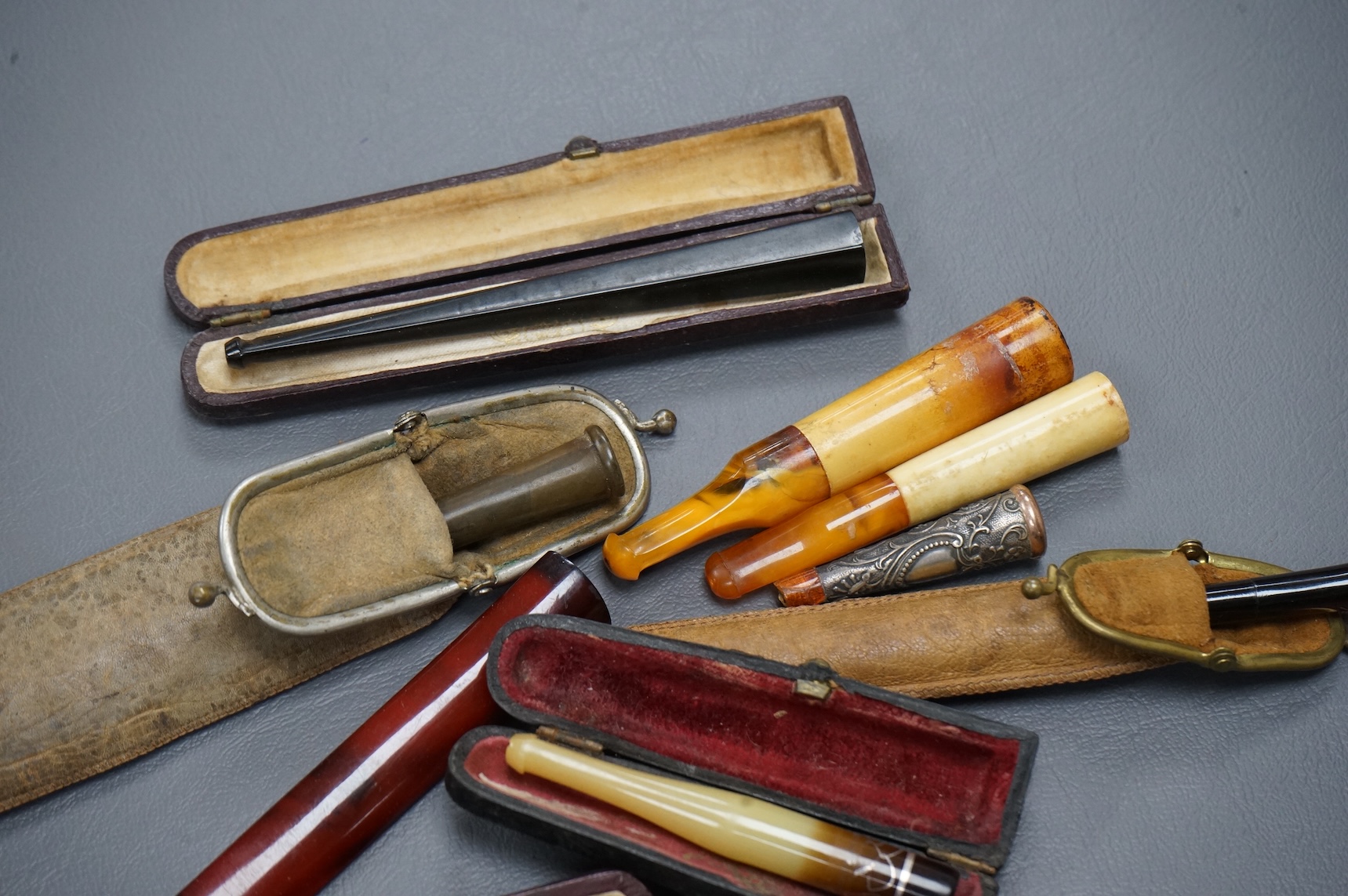 Twelve mixed cigarette and cheroot holders, some Cherry Amber, some with original cases